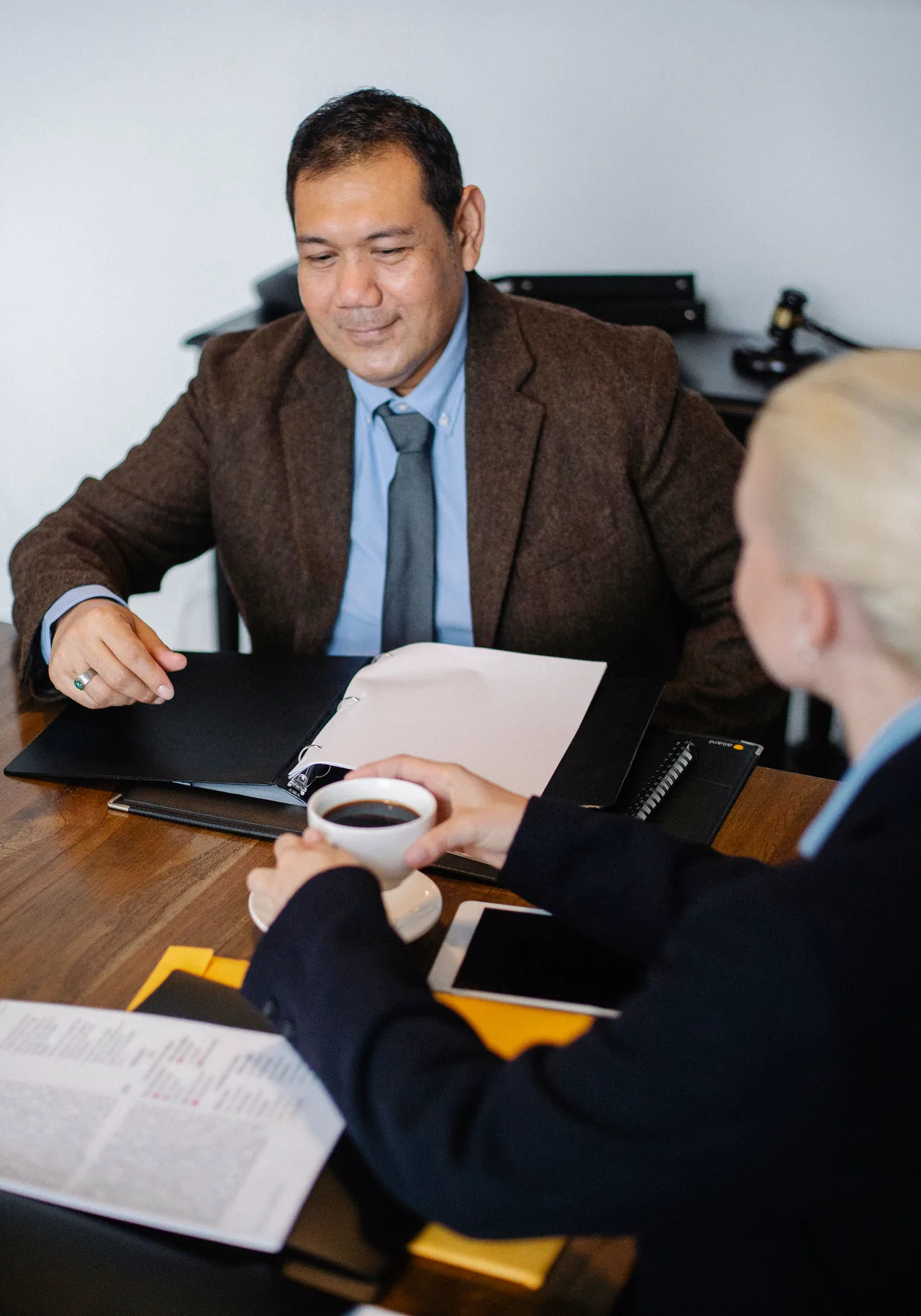 A lawyer at his desk going over a case with a client